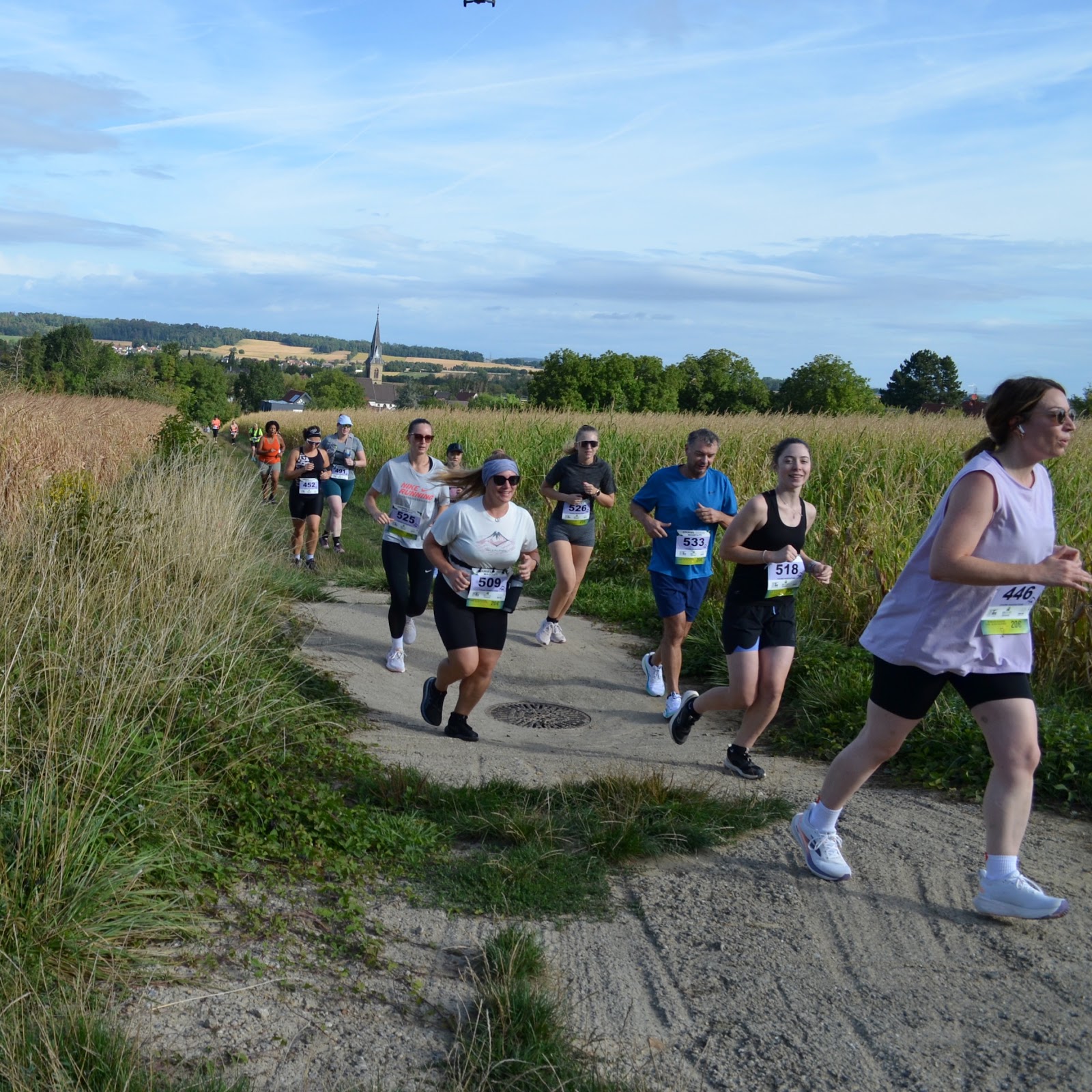 Les coureurs traversent la plaine entre les champs