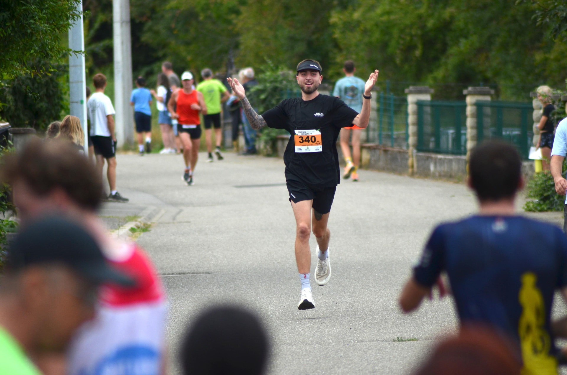 Coureur qui célèbre son arrivée au cœur du village, bras levés